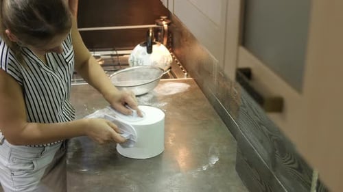 Woman Smoothing Fondant on Cake in Home Kitchen
