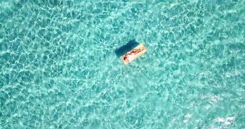Woman Relaxes on Tropical Water on Air Mattress