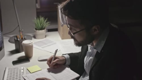 Man Working Hard in Dark Office