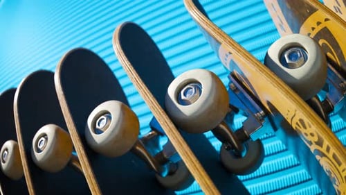 An endless row of standing skateboards with a blue wall in the background. 4KHD