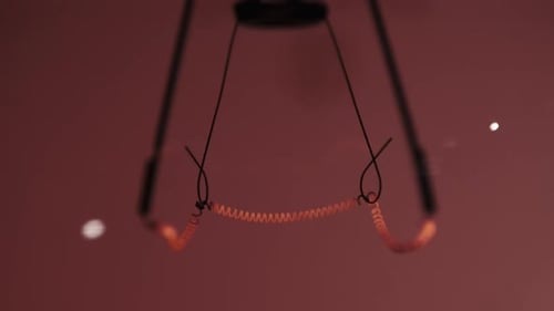 Das Wolframfilament in einer Glaslampe Nahaufnahme in Zeitlupe auf rotem Hintergrund