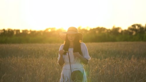 Young Girl With Straw Hat in Wheat Field