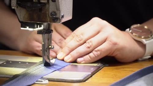 Woman hands using the sewing machine to sew the zipper