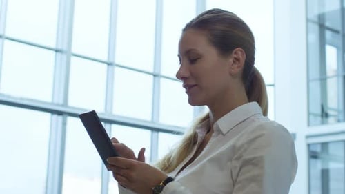 Professional Businesswoman Typing on Smartphone in Office Center
