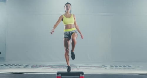 Woman Doing Step Aerobics in a Gym