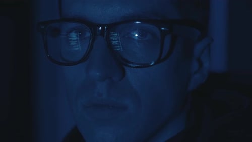Nahaufnahme Gesichtsporträt IT-Hacker-Programmierer Entwickler mit Brille bei der Arbeit Computer-Cyber-Angriff auf
