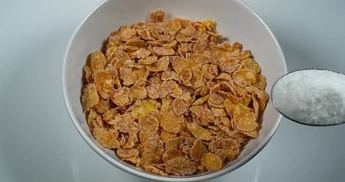Pouring Sugar into Bowl of Crispy Cornflakes