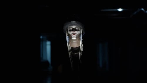 Sinister Man with Skeleton Makeup Appearing From Darkness When Light Falls on Him, Making Faces