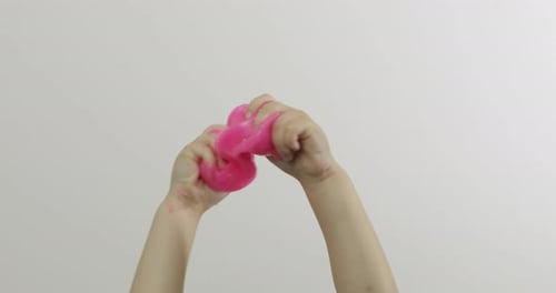 Child Hands Playing Oddly Satisfying Pink Slime on White Background. Antistress