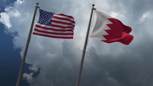 United States and Bahrain Flags Waving Together under Cloudy Sky