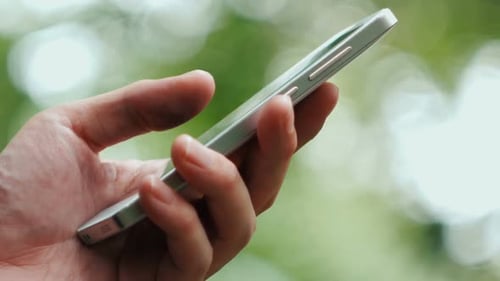 Hand Using Modern Smartphone Outdoors Close-Up