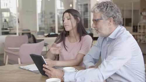 Business Team Collaborating on Tablet in Modern Office