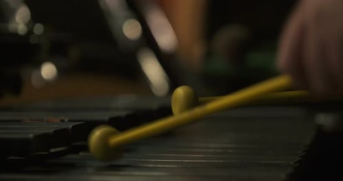 Playing a Xylophone with Yellow Mallets Close Up