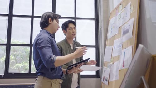 Two Young Adults Discussing Business Ideas at Office