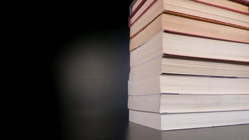 Stack of Hardback Books on Dark Surface