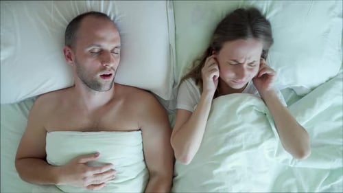 Une jeune femme frustrée mécontente ne peut pas dormir pendant que son petit ami ronfle dans son lit dans la chambre