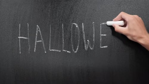 Writing "HALLOWEEN" on a Chalkboard with White Chalk