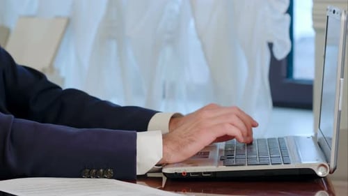 Man Typing on Laptop in Office Setting