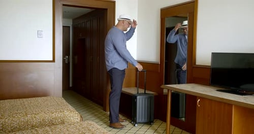 Tired Man Is Walking Inside Room of Hotel, Rolling His Suitcase, Smiling and Falling on Bed
