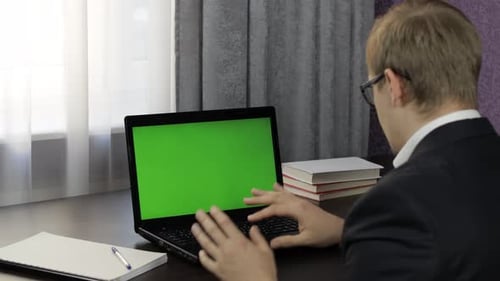 Man Have Video Call Conference on Laptop with Green Screen. Distance Work Online