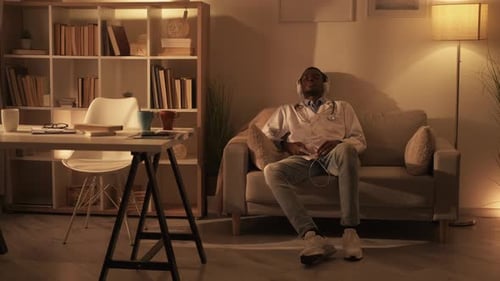 Young Adult Doctor Listening to Music at Home