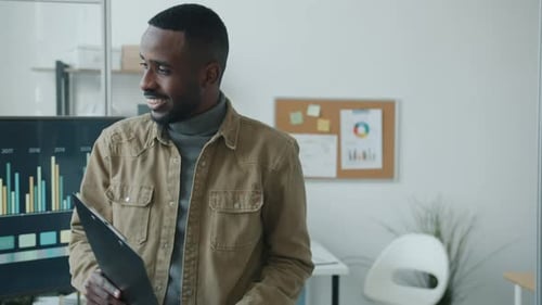 Confident African American Businessman Walking in Office Talking to Coworkers Then Using Laptop