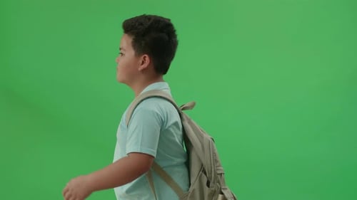 Side View Of Asian Boy Student Walking To School On Green Screen Chroma Key