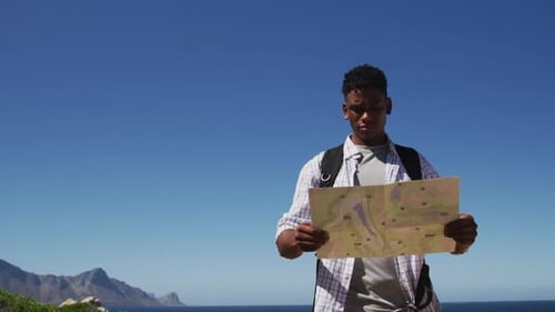 Man Reads Map for Outdoor Adventure on Sunny Day