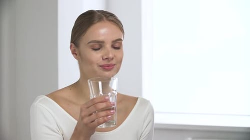Young Woman Taking Pill with Water