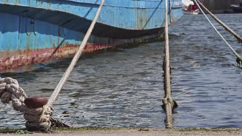 Blue Boat Tied to Dock with Ropes