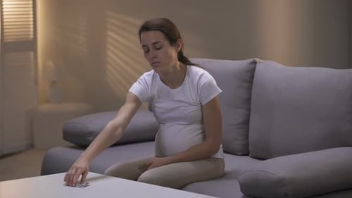Pauvre femme enceinte toxicomane prenant une pilule souffrant de dépression, manque de volonté