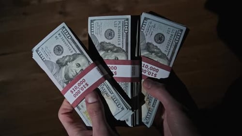 Hands Holding Stacks of Hundred Dollar Bills