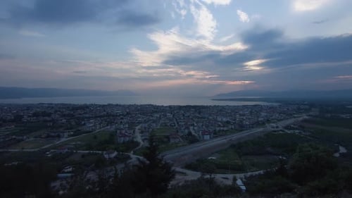 Sunset and city at sea. Time lapse.