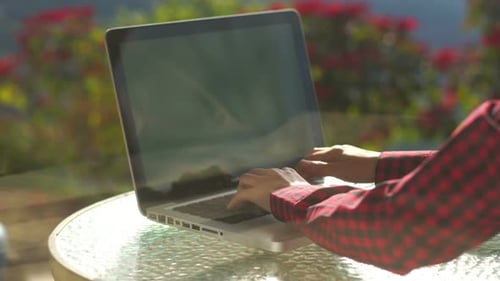 Hands Typing On Laptop Keyboard Outdoors