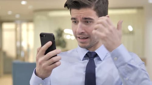 Excited Man Celebrates Good News on Smartphone