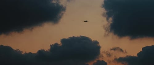 Flugzeug fliegt bei Sonnenuntergang in die Wolken, Zeitlupe 4K
