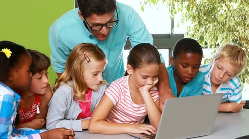 Teacher and kids using laptop in classroom