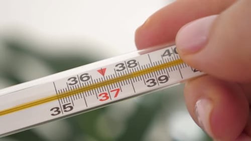 Thermometer mit hoher Temperatur in weiblicher Hand