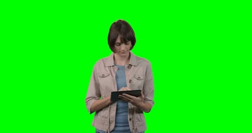 Woman using digital tablet against green background