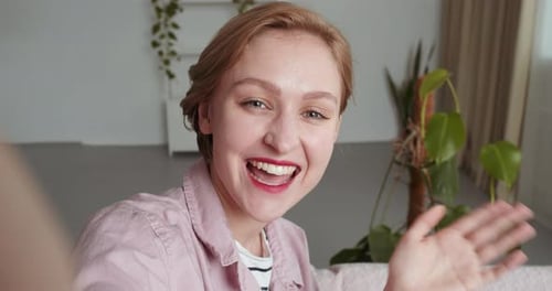 Smiling Woman Waving During a Video Call