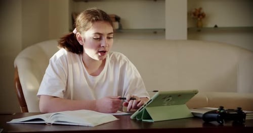 Girl Studying with Tablet and Book at Home