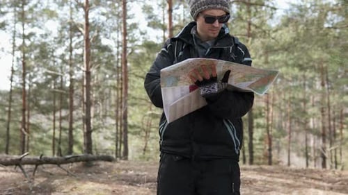 Man Navigating with Map in Dense Forest