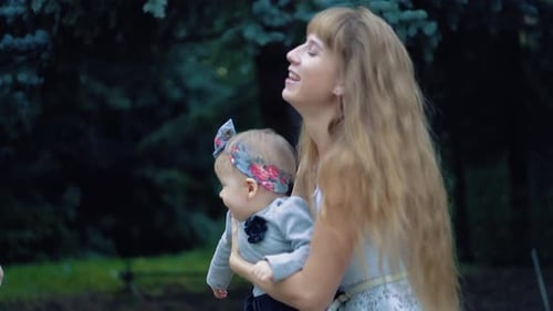 Loving Mother Holding Daughter in Park