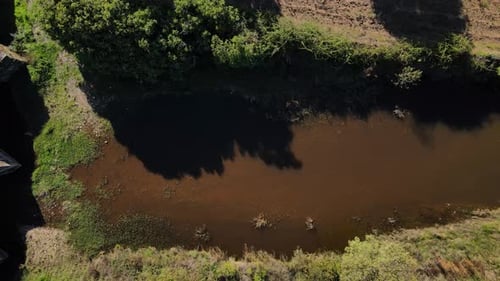 A drone pans over an ancient Roman bridge in a top-down view.