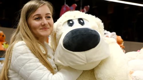 Woman Hugging a Large Stuffed Dog in a Store