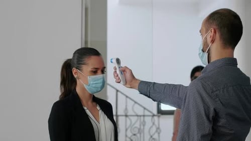 Freelancer with Protection Face Mask Measure Temperature with Thermometer