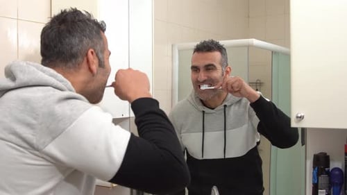 Man Brushing Teeth in a Bright Bathroom