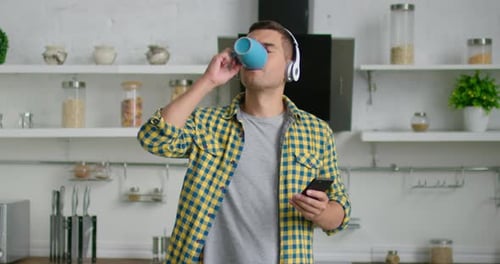 Man Listens to Music and Drinks Coffee