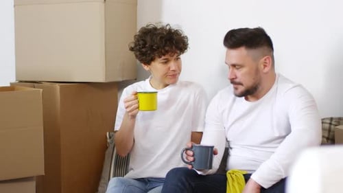 Weary Caucasian Couple Sitting on Floor in New Home