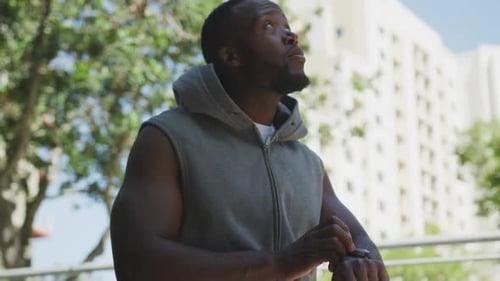 Man Puts Hood Up, Checks Fitness Watch
